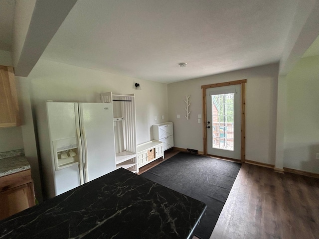 30290 7th Ave N, Swiss Twp, WI 54830 - unfurnished bedroom featuring white refrigerator with ice dispenser, washer / dryer, dark wood-type flooring, and access to outside
