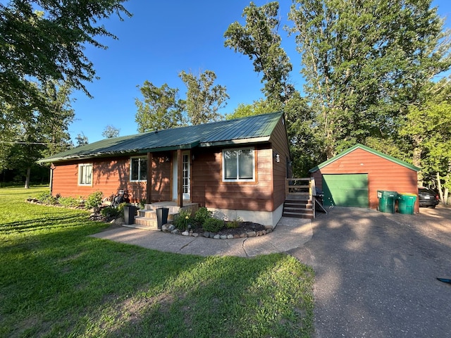 30290 7th Ave N, Swiss Twp, WI 54830 - view of front facade with a garage, an outdoor structure, a front yard, asphalt driveway, and a metal roof