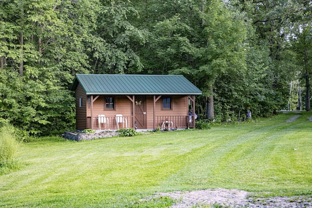 39070 County Highway 67, Newton Twp, MN 56567 - view of front of house featuring covered porch, a front lawn, a metal roof, and a forest view