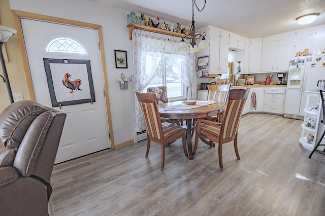 39070 County Highway 67, Newton Twp, MN 56567 - dining room featuring light wood finished floors, a chandelier, and a baseboard heating unit