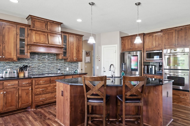 10412 Florida Ave N, Brooklyn Park, MN 55445 - kitchen with stainless steel appliances, dark wood-style flooring, an island with sink, decorative backsplash, and brown cabinetry