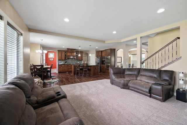 10412 Florida Ave N, Brooklyn Park, MN 55445 - living room featuring arched walkways, recessed lighting, dark wood-type flooring, a chandelier, and stairs