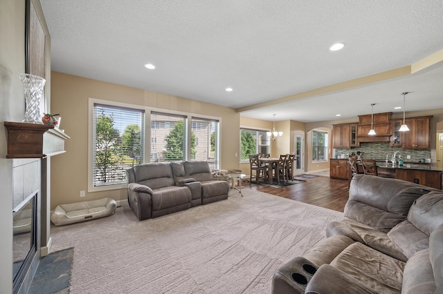 10412 Florida Ave N, Brooklyn Park, MN 55445 - living room featuring a tiled fireplace, dark carpet, recessed lighting, a chandelier, and a textured ceiling