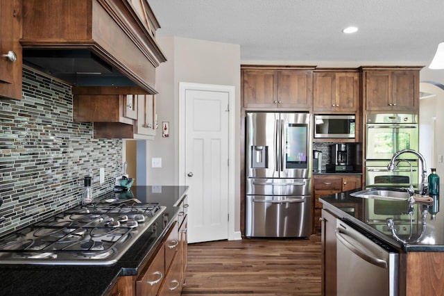 10412 Florida Ave N, Brooklyn Park, MN 55445 - kitchen with stainless steel appliances, dark wood-style flooring, tasteful backsplash, custom exhaust hood, and dark stone counters