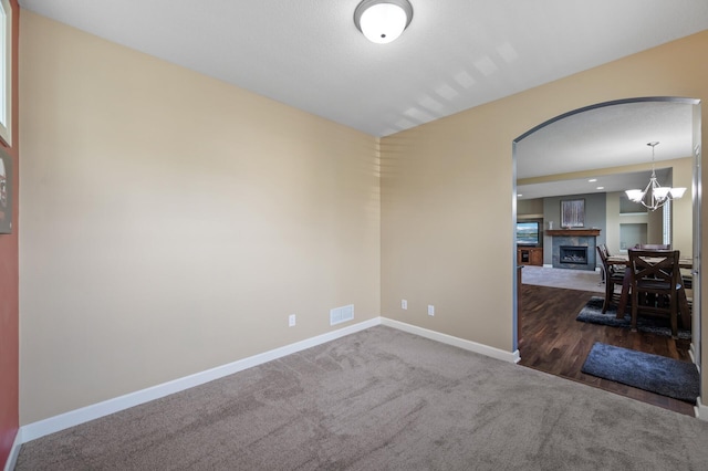 10412 Florida Ave N, Brooklyn Park, MN 55445 - empty room with carpet floors, a fireplace, and a chandelier