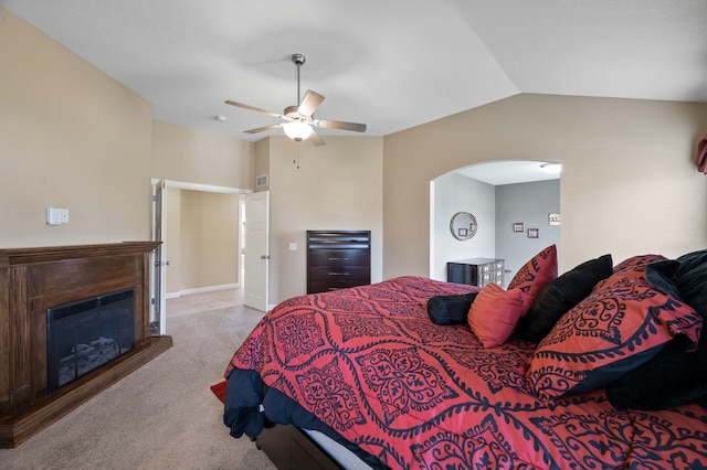 10412 Florida Ave N, Brooklyn Park, MN 55445 - carpeted bedroom featuring arched walkways, a glass covered fireplace, lofted ceiling, and ceiling fan