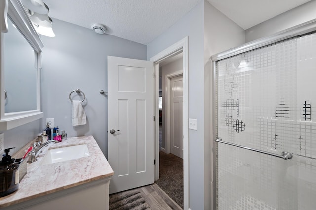 10412 Florida Ave N, Brooklyn Park, MN 55445 - bathroom with a stall shower, vanity, and wood finished floors