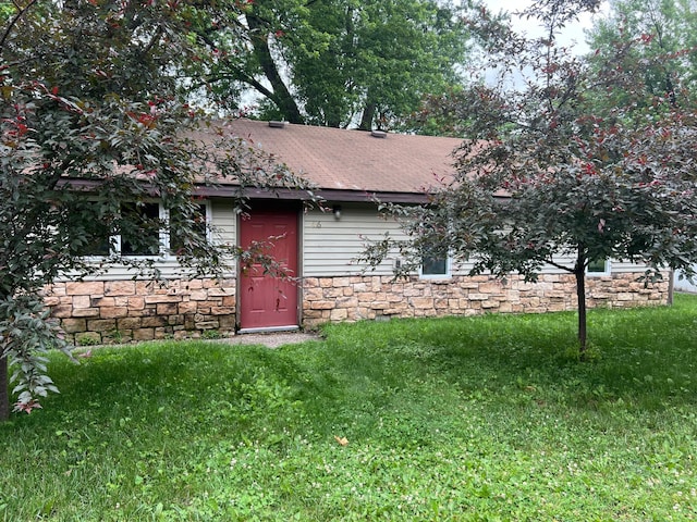 416 Wallace St N, Delano, MN 55328 - view of front of property featuring stone siding, a front lawn, and a shingled roof