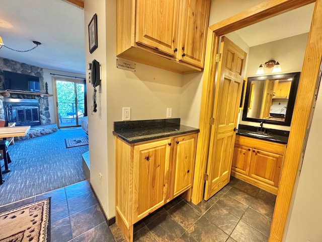 140 Bridge Run Ln Unit C, Lutsen Twp, MN 55615 - kitchen featuring dark countertops, a stone fireplace, dark stone finish floors, and open floor plan