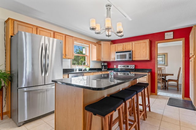 1405 17th Dr SW, Austin, MN 55912 - kitchen with stainless steel appliances, a chandelier, light tile patterned flooring, a breakfast bar, and a kitchen island
