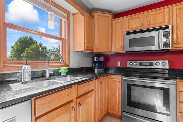 1405 17th Dr SW, Austin, MN 55912 - kitchen featuring stainless steel appliances, dark stone countertops, pendant lighting, and light tile patterned flooring
