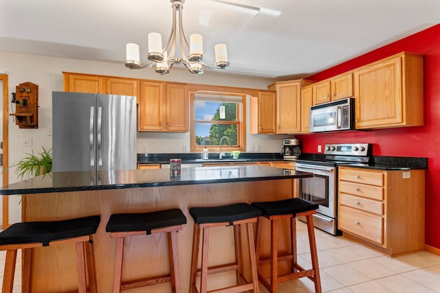 1405 17th Dr SW, Austin, MN 55912 - kitchen featuring stainless steel appliances, a chandelier, a breakfast bar, light tile patterned floors, and hanging light fixtures