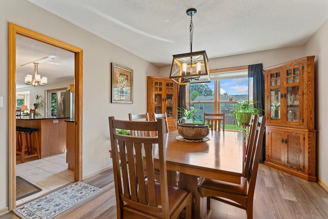1405 17th Dr SW, Austin, MN 55912 - dining area with a chandelier, light wood finished floors, and a textured ceiling