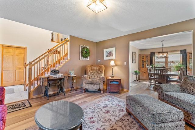 1405 17th Dr SW, Austin, MN 55912 - living area featuring stairs, wood finished floors, a textured ceiling, and a chandelier