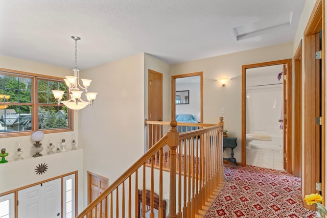 1405 17th Dr SW, Austin, MN 55912 - hall with an upstairs landing, a chandelier, attic access, and light tile patterned floors