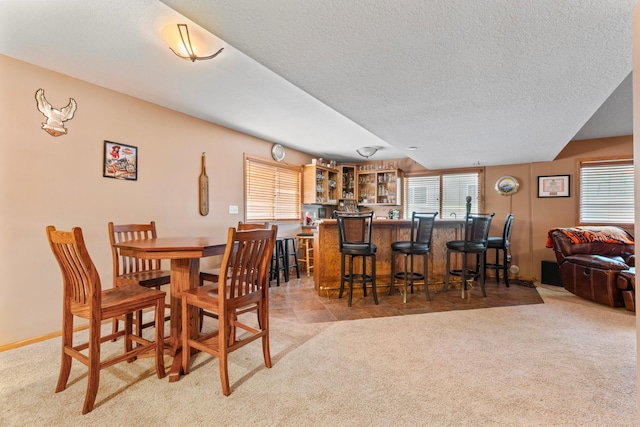 1405 17th Dr SW, Austin, MN 55912 - dining space featuring bar with sink, light colored carpet, and a textured ceiling