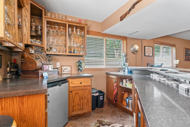 1405 17th Dr SW, Austin, MN 55912 - kitchen featuring refrigerator, brown cabinetry, open shelves, and dark countertops