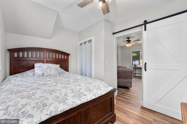 W10429 Hinker Rd, Foster Twp, WI 54493 - bedroom featuring a barn door, light wood finished floors, and ceiling fan