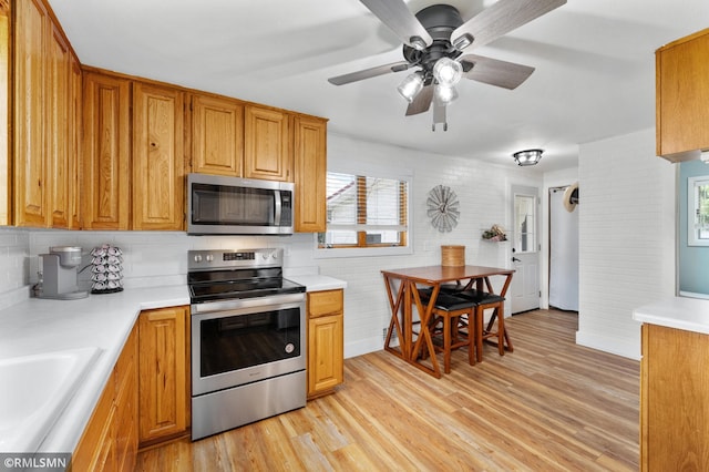 W10429 Hinker Rd, Foster Twp, WI 54493 - kitchen with appliances with stainless steel finishes, light countertops, light wood-type flooring, and ceiling fan