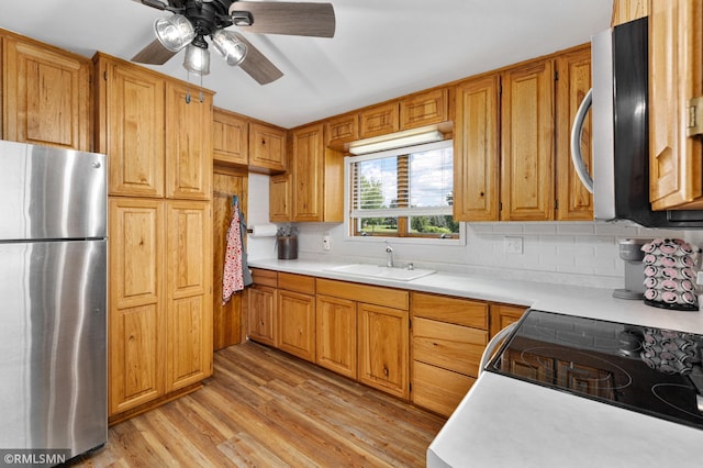 W10429 Hinker Rd, Foster Twp, WI 54493 - kitchen with stainless steel appliances, light countertops, light wood-style flooring, and decorative backsplash