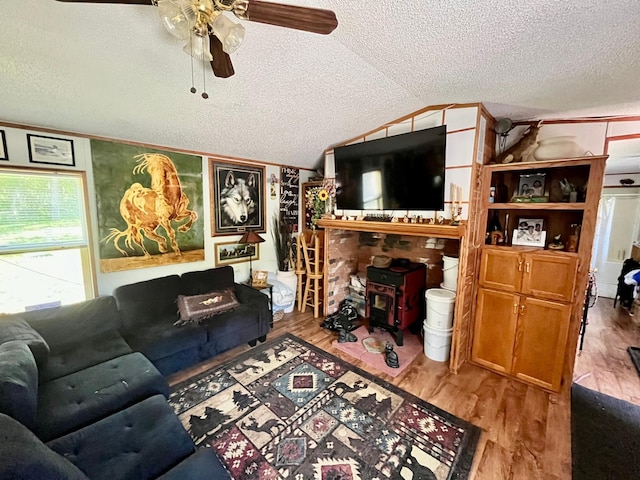 31700 Cherry Lake Rd, Ogema, MN 56569 - living area with a textured ceiling, ceiling fan, wood finished floors, vaulted ceiling, and a wood stove