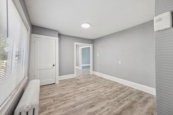 1711 Newton Ave N, Minneapolis, MN 55411 - empty room with wood finished floors and radiator