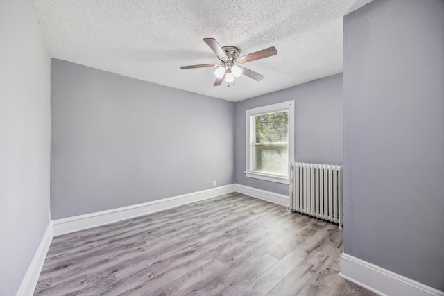 1711 Newton Ave N, Minneapolis, MN 55411 - empty room with radiator heating unit, a textured ceiling, ceiling fan, and wood finished floors