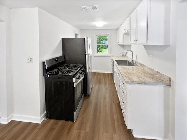 6043 17th St N, Oakdale, MN 55128 - kitchen with stainless steel appliances, wood finished floors, light countertops, and white cabinets