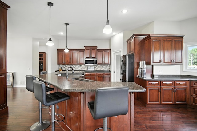 1570 Wood Duck Ln NE, Owatonna, MN 55060 - kitchen featuring stainless steel appliances, recessed lighting, backsplash, dark wood finished floors, and a spacious island