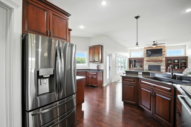 1570 Wood Duck Ln NE, Owatonna, MN 55060 - kitchen featuring stainless steel fridge, dark countertops, open floor plan, a stone fireplace, and ceiling fan