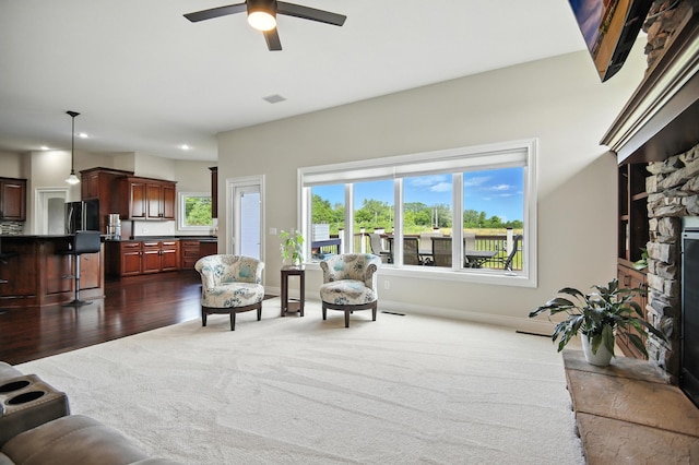 1570 Wood Duck Ln NE, Owatonna, MN 55060 - living area featuring a fireplace, ceiling fan, dark wood-style flooring, recessed lighting, and dark colored carpet