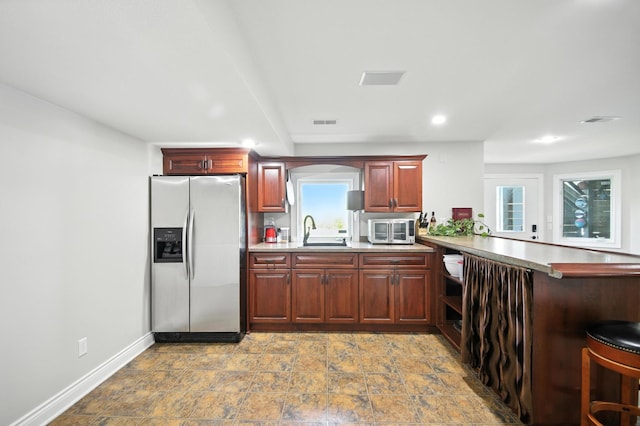 1570 Wood Duck Ln NE, Owatonna, MN 55060 - kitchen featuring appliances with stainless steel finishes, a peninsula, light countertops, recessed lighting, and stone finish flooring