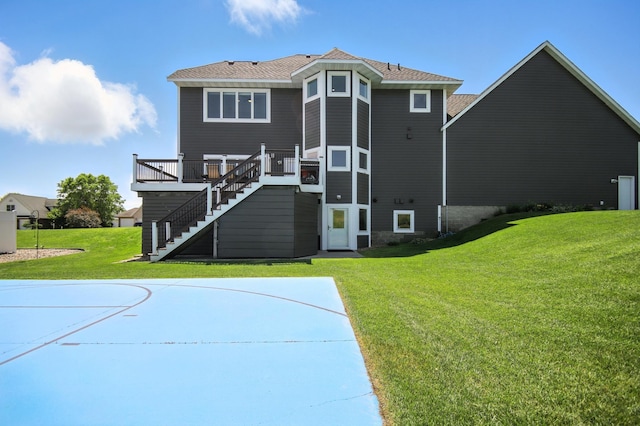1570 Wood Duck Ln NE, Owatonna, MN 55060 - back of property with stairs, a lawn, basketball court, and a wooden deck