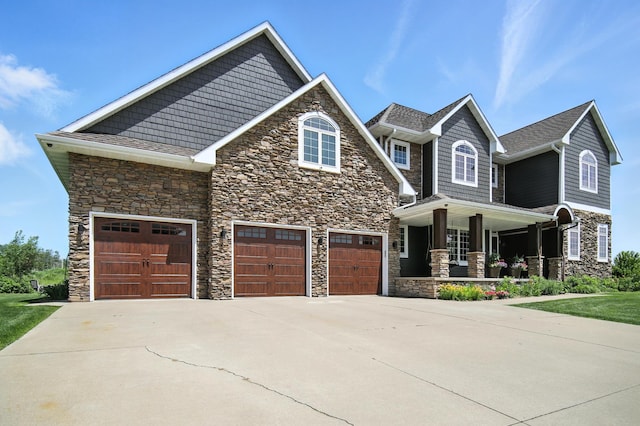 1570 Wood Duck Ln NE, Owatonna, MN 55060 - craftsman house with stone siding, covered porch, concrete driveway, and an attached garage