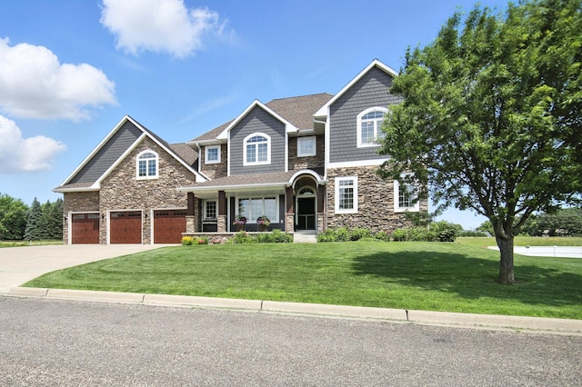 1570 Wood Duck Ln NE, Owatonna, MN 55060 - view of front facade featuring stone siding, a front yard, covered porch, driveway, and an attached garage
