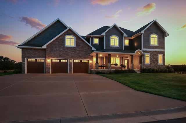 1570 Wood Duck Ln NE, Owatonna, MN 55060 - view of front of home featuring a porch, stone siding, a lawn, and concrete driveway