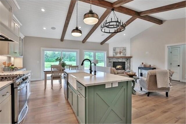 7591 255th St, Wyoming, MN 55092 - kitchen featuring green cabinetry, stainless steel appliances, custom exhaust hood, light countertops, and light wood finished floors