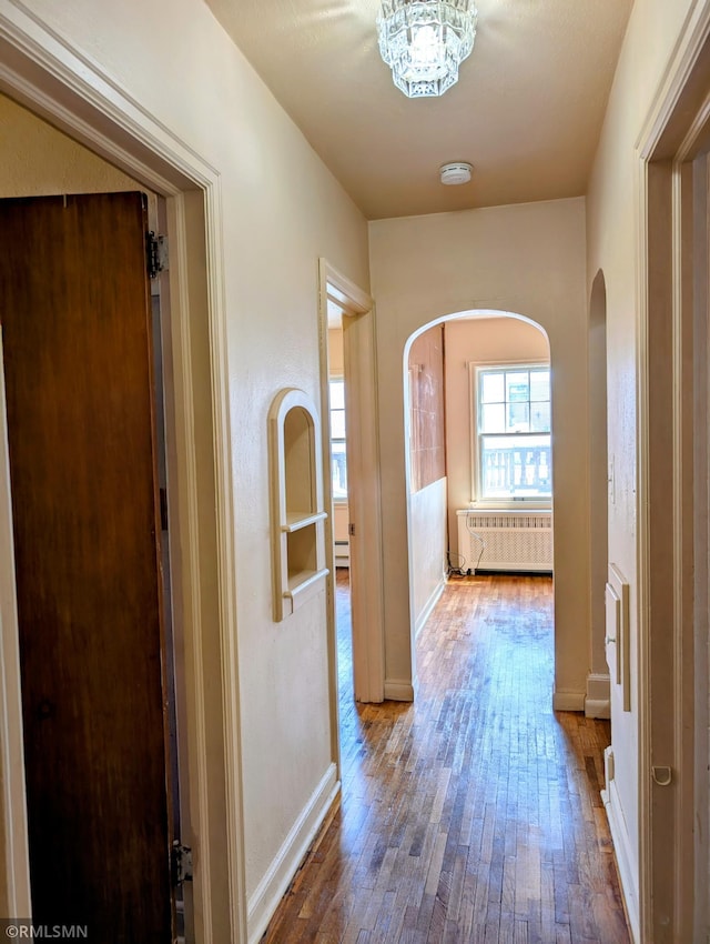 711 Main St N, Browerville, MN 56438 - hall featuring arched walkways, radiator, and hardwood / wood-style floors