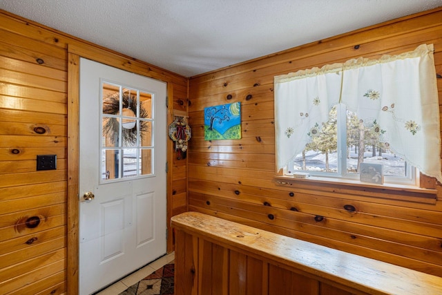 24621 Long Lake Rd, Bigfork, MN 56628 - entryway featuring wood walls, a textured ceiling, and light tile patterned floors
