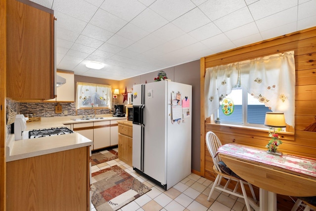 24621 Long Lake Rd, Bigfork, MN 56628 - kitchen featuring white appliances, light countertops, tasteful backsplash, and wood walls