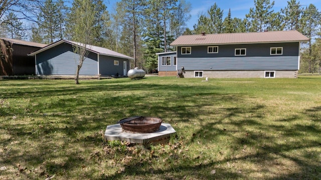 24621 Long Lake Rd, Bigfork, MN 56628 - back of house with an outdoor fire pit, a lawn, and a metal roof