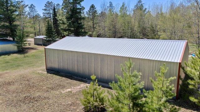 24621 Long Lake Rd, Bigfork, MN 56628 - view of side of property featuring an outdoor structure, an outbuilding, and a wooded view