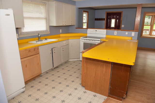 304 Pearl St, Spring Valley, MN 55975 - kitchen featuring white appliances, a peninsula, healthy amount of natural light, and light countertops