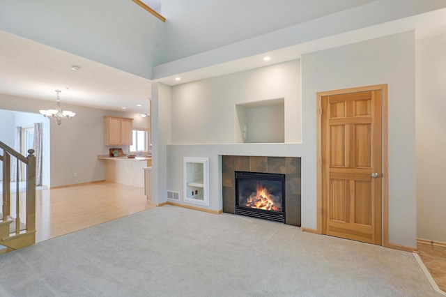 9633 Belmont Ln, Eden Prairie, MN 55347 - unfurnished living room with light colored carpet, a tile fireplace, a chandelier, recessed lighting, and stairway