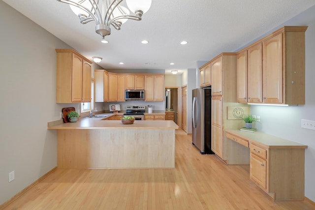 9633 Belmont Ln, Eden Prairie, MN 55347 - kitchen with appliances with stainless steel finishes, light brown cabinetry, light wood finished floors, a peninsula, and light countertops