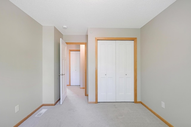 9633 Belmont Ln, Eden Prairie, MN 55347 - unfurnished bedroom featuring light colored carpet, a closet, and a textured ceiling