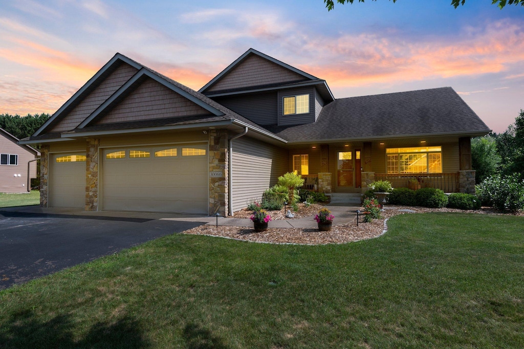 30066 Fox Run Rd, Stacy, MN 55079 - craftsman inspired home with stone siding, driveway, covered porch, a yard, and an attached garage