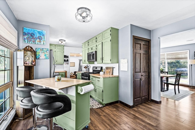 315 Ugstad Rd, Proctor, MN 55810 - kitchen featuring green cabinets, stainless steel microwave, range with gas cooktop, dark wood-style flooring, and plenty of natural light