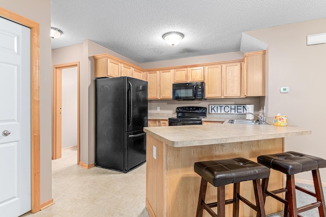16418 Elm Creek Ln Unit 4027, Lakeville, MN 55044 - kitchen with black appliances, light brown cabinets, a peninsula, light countertops, and a breakfast bar