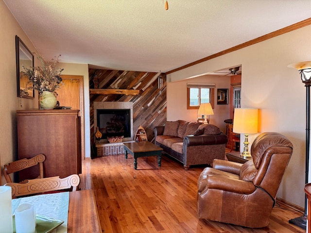 15467 Twilight Rd, Onamia, MN 56359 - living room featuring light wood-type flooring, ceiling fan, a textured ceiling, wooden walls, and crown molding